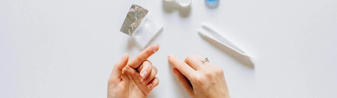 Hands Handling Contact Lens With Lens Care Accessories