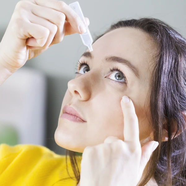 Person Applying Lubricating Eye Drops To Eye